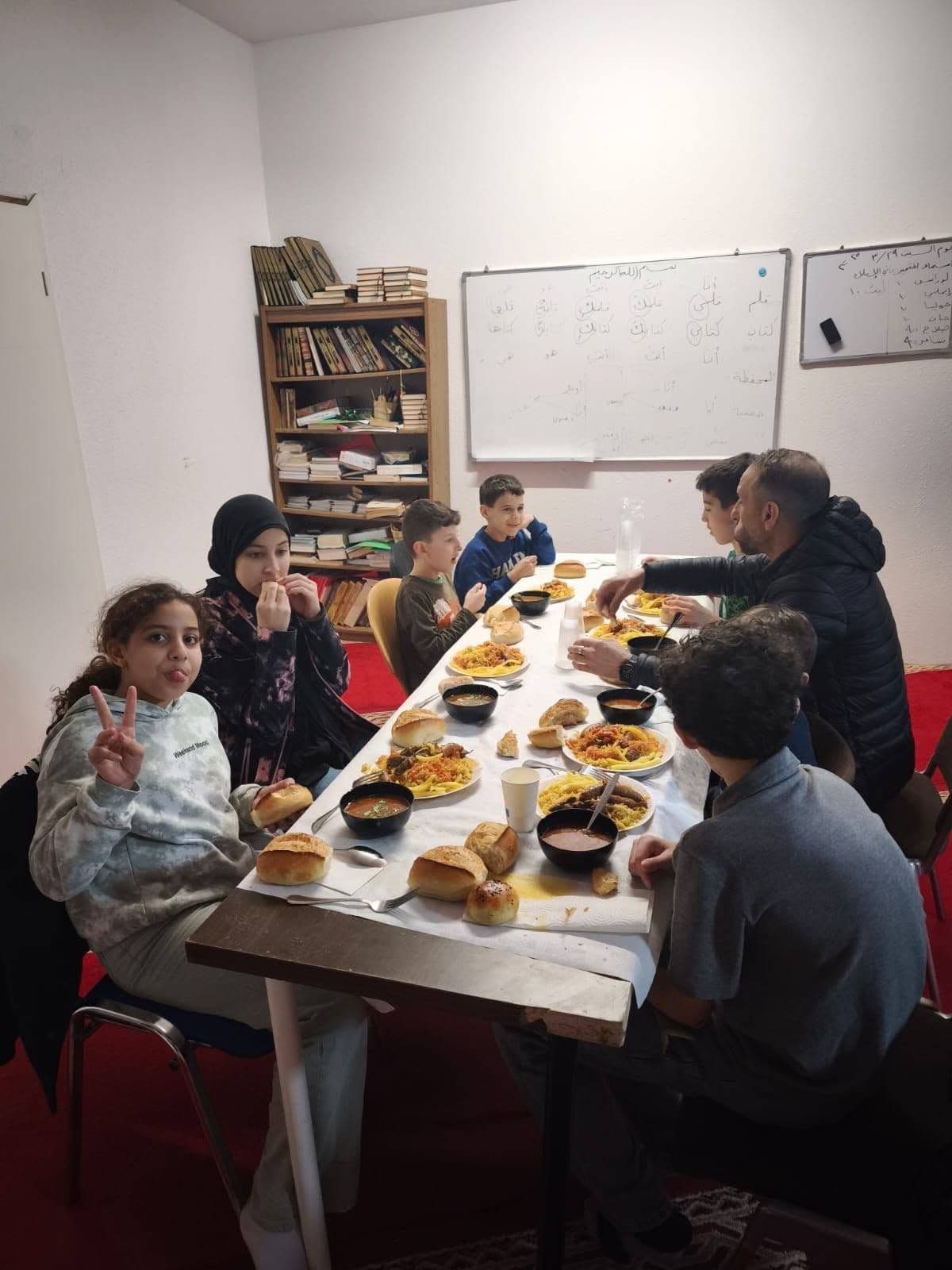 Frauen, Männer und Kinder beim gemeinsamen Essen