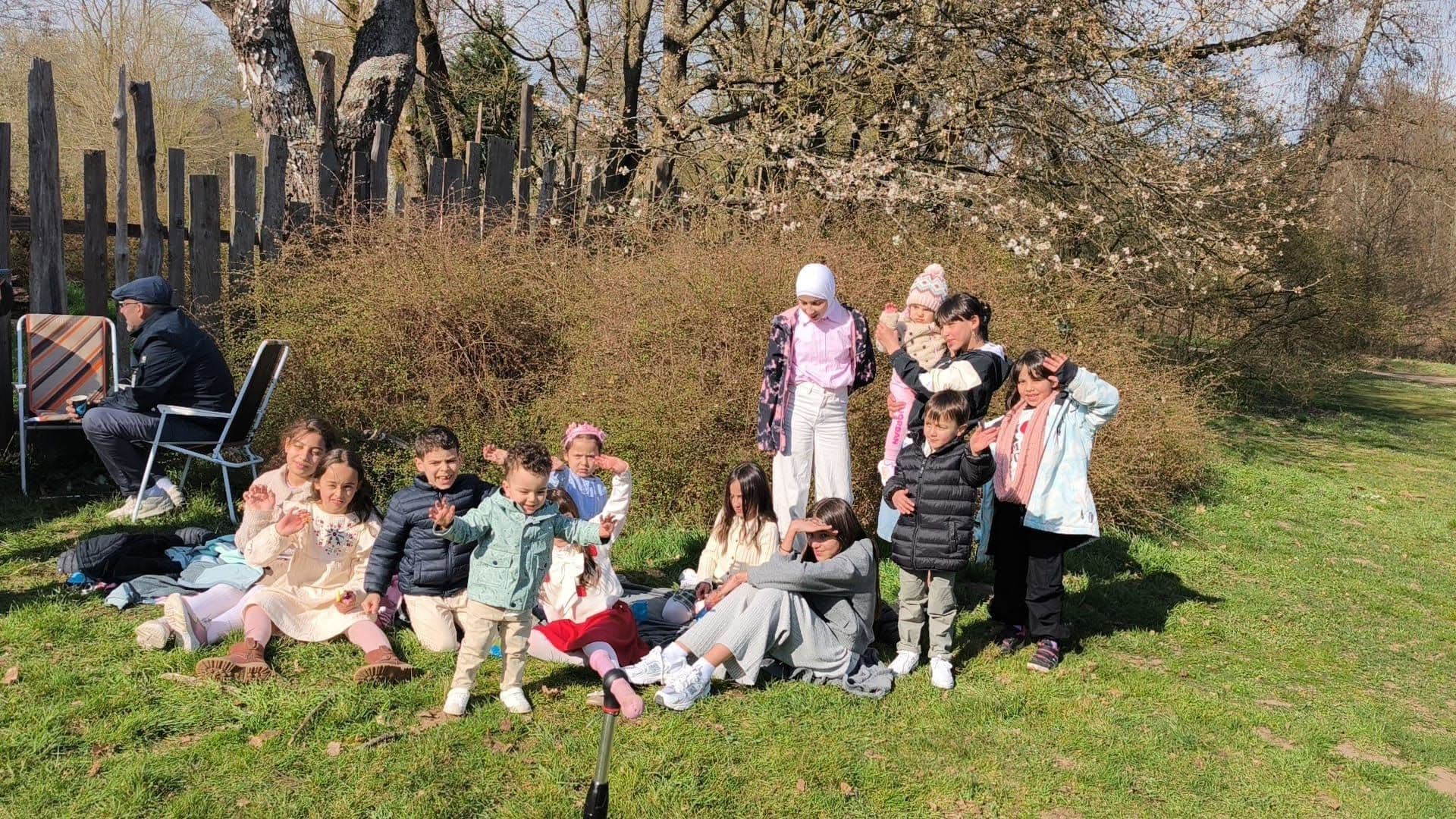 Kinder und Familien auf einer Wiese bei einem Ausflug