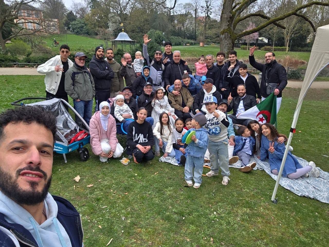 Gruppenfoto vieler Familien mit Kindern im Park, als Selfie aufgenommen