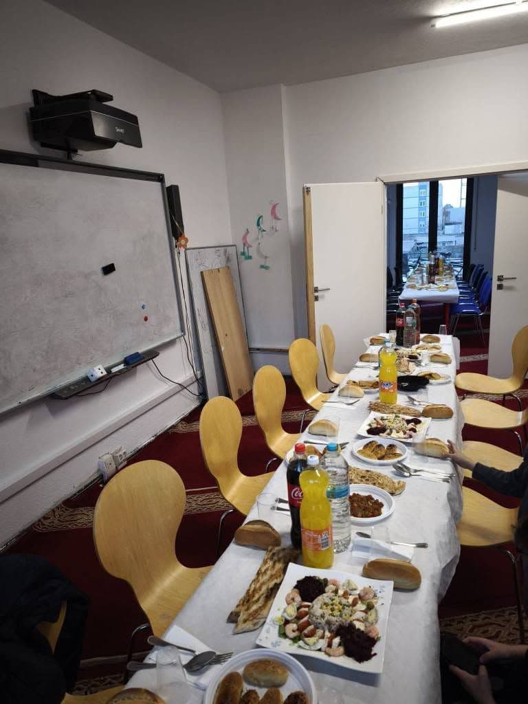 Eine lange Tafel mit Speisen und Getränken in einem Saal