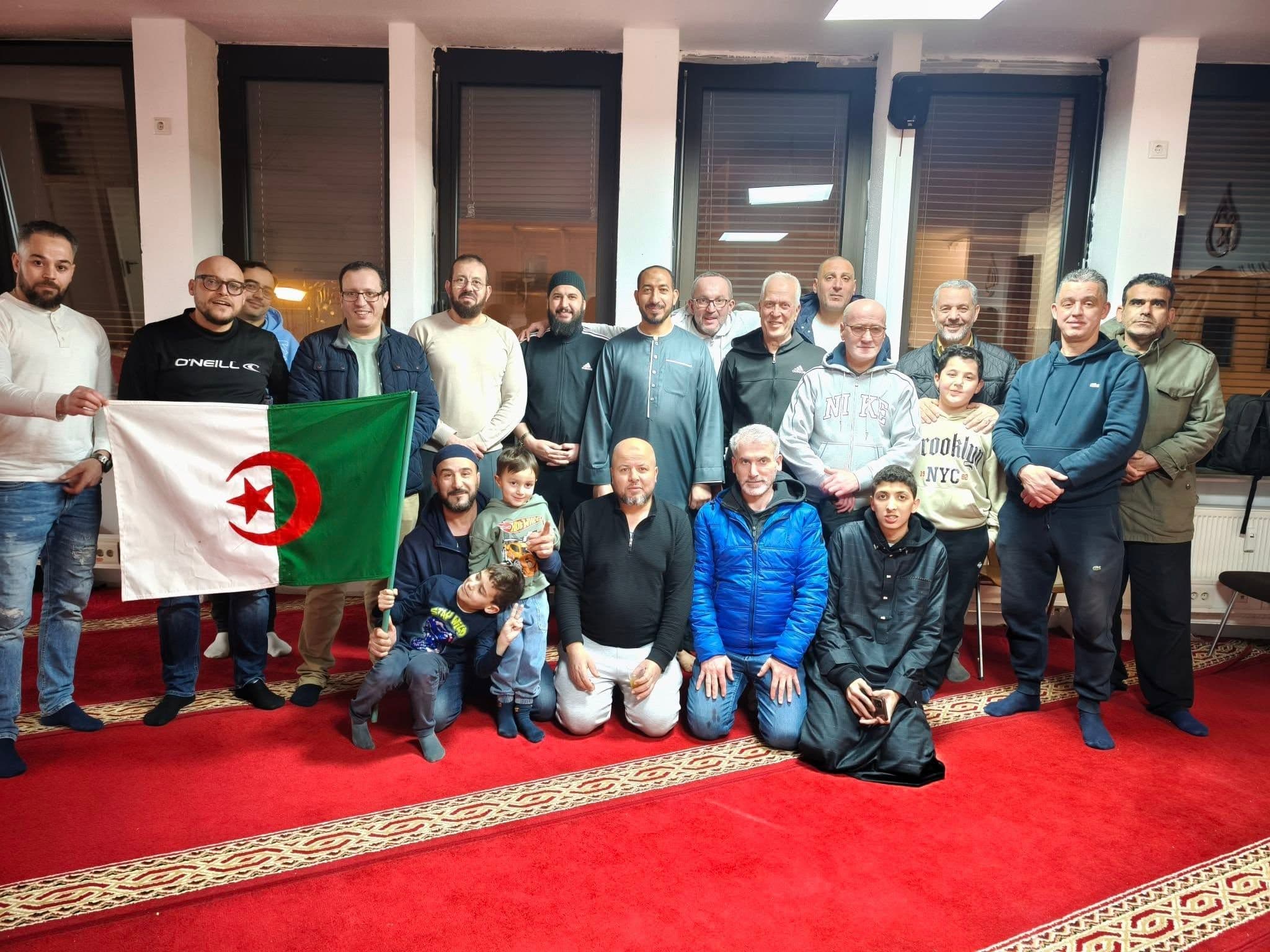 Mitglieder und Kinder des Vereins bei einem Treffen, vorn die algerische Flagge
